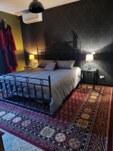 a bedroom with a bed with two lamps and a rug at Odessa at leavers Hotel in Creswick