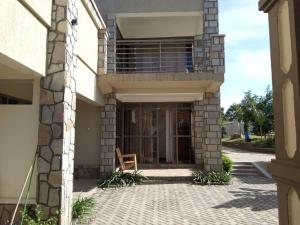 Casa con balcón y patio con silla en Bucolic Heritage Resort, en Adjumani