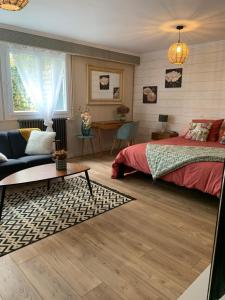 a bedroom with a bed and a couch at Au fil de l’eau in Saint-Gelais +1 photo