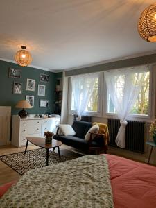 uma sala de estar com uma cama, um sofá e janelas em Au fil de l’eau em Saint-Gelais