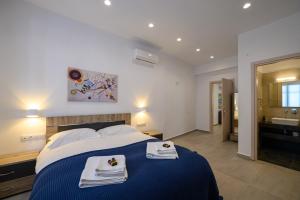 - une chambre avec un lit bleu et des serviettes dans l'établissement Ilianas Home, à Kalamata