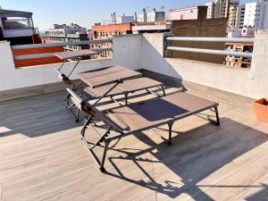Luxury Attics Avenida Italia PARKING INCLUIDO في هويلفا: طاولتان للتنزه على سقف مبنى