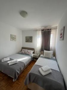 - une chambre avec 2 lits et des serviettes dans l'établissement APARTMANI "ZUKA", à Korčula