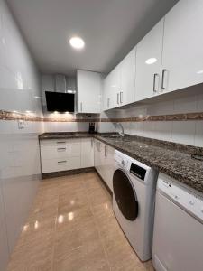 uma cozinha com armários brancos e uma máquina de lavar louça em TORREMOLINOS CENTRO - Beautiful , newly renovated 2 bedroom apartment em Torremolinos