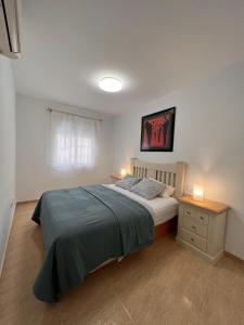 um quarto com uma cama e duas mesas de cabeceira com luzes em TORREMOLINOS CENTRO - Beautiful , newly renovated 2 bedroom apartment em Torremolinos