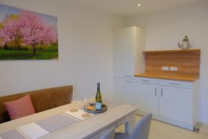a kitchen with a table with a bottle of wine at Ferienweingut Wissing Wohnung Theo in Gleiszellen-Gleishorbach