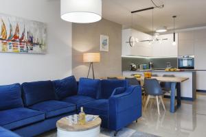 a living room with a blue couch and a kitchen at La vita e bella in Pješčana Uvala