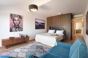 a bedroom with a bed and a blue couch at La vita e bella in Pješčana Uvala