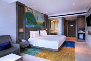 una camera con un letto bianco e una sedia di Grand Mercure Jakarta Kemayoran a Giacarta