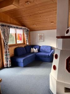 uma sala de estar com sofás azuis numa casa em Ferienwohnung Gleirscher em Neustift im Stubaital