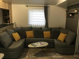 a living room with a gray couch with yellow pillows at La Baume 515 in Fréjus