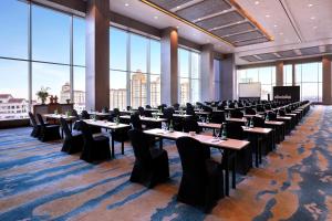 a large room with tables and chairs and large windows at Grand Mercure Jakarta Kemayoran in Jakarta +75 photos