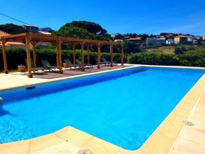 una piscina con cenador y agua azul en Hôtel Sole Mare, en Calvi