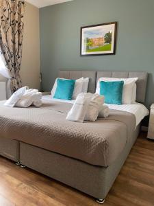 two beds in a room with blue and white pillows at The Hideaway @ Watergate eye Farm in Barnard Castle