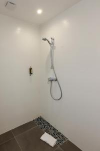 a bathroom with a shower in a white wall at Hôtel Méditerranée in Calvi