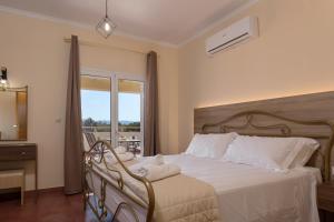 1 dormitorio con 1 cama blanca y ventana en Villa Melody Complex en Akrotiri
