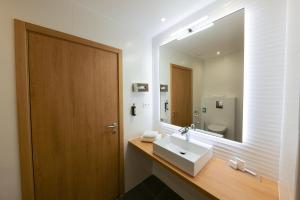 a bathroom with a sink and a large mirror at Hôtel Méditerranée in Calvi