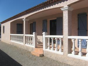 una casa con ringhiera bianca su un balcone di Chambre d'hôtes à Usclas d'Hérault a Usclas-lʼHérault