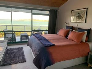 1 dormitorio con 1 cama y vistas al océano en Harbour Lane Apartment, en Whangarei