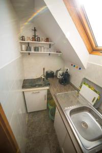 a small kitchen with a sink and a rainbow at TIFFANY Apartman in Jenő