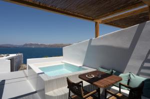 balcone con vasca immersione ad acqua fredda, tavolo e sedie di Hotel Goulielmos ad Akrotírion