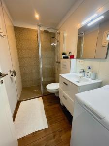 uma casa de banho com um chuveiro, um WC e um lavatório. em Harmony Apartments em Arona