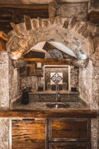 una cucina con lavandino in una stanza in pietra di Appartamenti montemezzo le case in pietra Vista lago a Gera Lario
