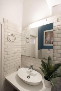 a bathroom with a white sink and a potted plant at Blue Ark Comfort near Acropolis in Athens