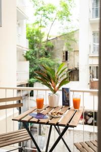 einen Tisch auf einem Balkon mit Topfpflanze in der Unterkunft Blue Ark Comfort near Acropolis in Athen