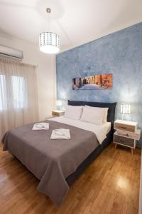 ein Schlafzimmer mit einem großen Bett mit blauer Wand in der Unterkunft Blue Ark Comfort near Acropolis in Athen