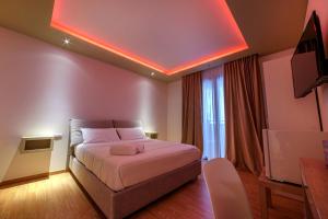 a hotel room with a bed and a tv at Aminta - Rooms & Wellness in Andria
