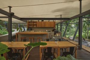 una cocina abierta y una zona de comedor con mesas de madera. en Lintang Luku Tent Resort, en Banyuwangi