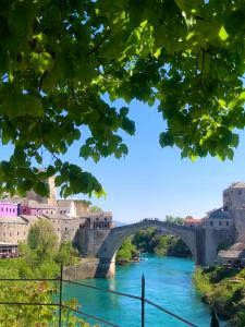 a bridge over a river in a city at Vienna Story Guesthouse in Mostar