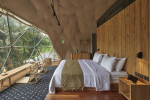 a bedroom with a bed and a large window at Lintang Luku Tent Resort in Banyuwangi
