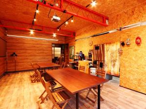 宿屋DOYA في Miyada: غرفة طعام مع طاولات وكراسي خشبية