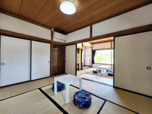 MiyadaにあるGuesthouse YadoyaDOYAのテーブル付きの部屋、ガラスの引き戸付きの部屋