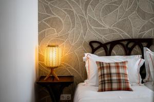 a bedroom with a bed and a lamp on a table at Mouzinho 129 - Sobreiro in Porto
