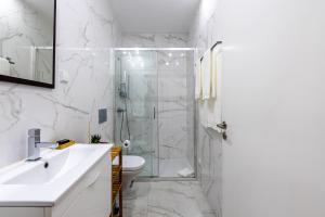 a white bathroom with a shower and a toilet at Mouzinho 129 - Sobreiro in Porto