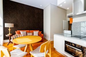 a kitchen with an orange table and chairs in a room at Mouzinho 129 - Sobreiro in Porto