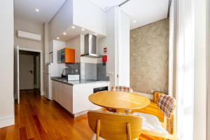 a kitchen with a wooden table and chairs in a room at Mouzinho 129 - Sobreiro in Porto