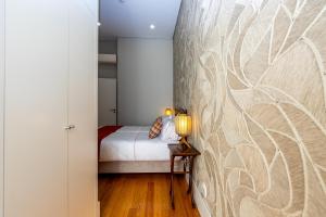 a bedroom with a bed and a wall at Mouzinho 129 - Sobreiro in Porto +6 photos