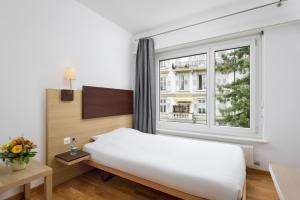ein Schlafzimmer mit einem Bett und einem großen Fenster in der Unterkunft Bon Port in Montreux