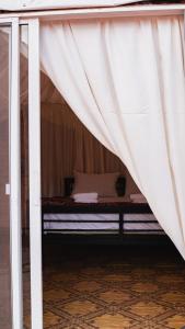 a bed in a room with a white curtain at Luner Camp at Wadi Rum in Wadi Rum
