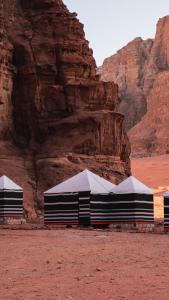 a group of tents in the desert near a mountain at Luner Camp at Wadi Rum in Wadi Rum