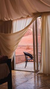 a bedroom with a view of the desert from a balcony at Luner Camp at Wadi Rum in Wadi Rum