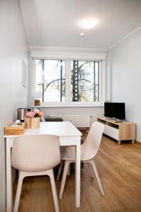 ein weißes Esszimmer mit einem weißen Tisch und Stühlen in der Unterkunft Pepleri Studio 49 in Tartu