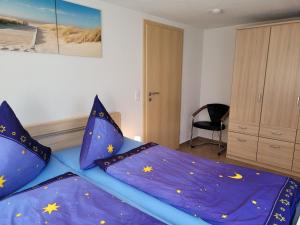 ツィノヴィッツにある2-Raum Ferienwohnungのベッドルーム1室(黄色い星の紫色の掛け布団付きのベッド1台付)