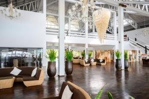 a large lobby with couches and chairs and a chandelier at VOI Andilana Beach Resort in Nosy Be