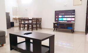 a living room with a table and chairs and a tv at Chippy Apartments No.27 in Chennai