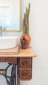 een badkamer met een wastafel en een cactus op een tafel bij The Central Cottage - Port Lincoln in Port Lincoln